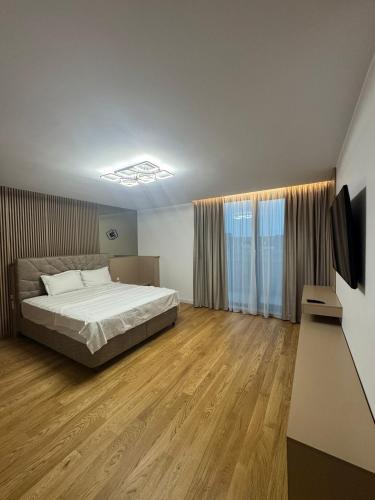 een slaapkamer met een bed en een televisie. bij Knight Home in Voluntari