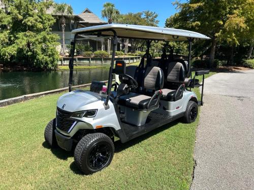 a golf cart parked on the grass near the water at Turnberry 8561 in Destin