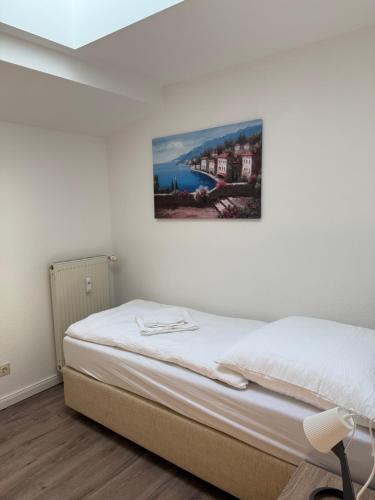 een bed in een kamer met een schilderij aan de muur bij Ferienwohnungen in Röblingen 