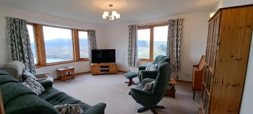 a living room with a couch and chairs and windows at Solheim Self Catering in Whiteness
