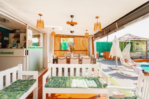 a living room with white chairs and a pool at Caline VIP Luxury Jacuzzi &, Swimming Pool MEWS in Cape Town