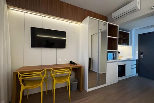 a kitchen with a table and yellow chairs in a room at Apartamentos Luxuosos a Passos do Mar no Helbor Stay - Airbn Santos in Santos
