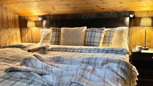 een slaapkamer met een groot bed met een houten wand bij Modern and cozy mountain cabin - panoramic view! in Torvetjørn
