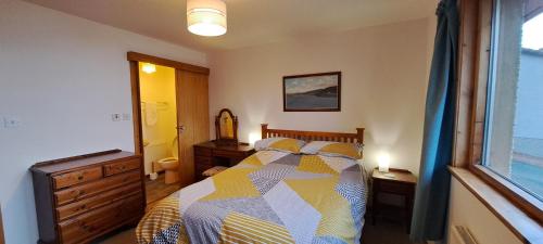 a bedroom with a bed and a window at Solheim Self Catering in Whiteness