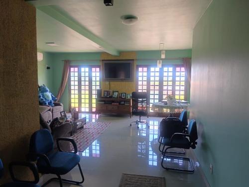 a room with chairs and a living room with windows at FICOS Hospedagem in São Gabriel