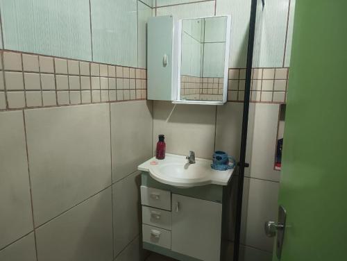 a bathroom with a sink and a mirror at FICOS Hospedagem in São Gabriel