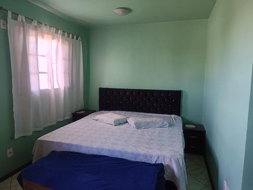 a bedroom with a bed with two pillows on it at FICOS Hospedagem in São Gabriel