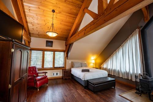 雷夫尔斯托克Timberloft by Revelstoke Vacations的一间卧室，有一张床和一把红椅子