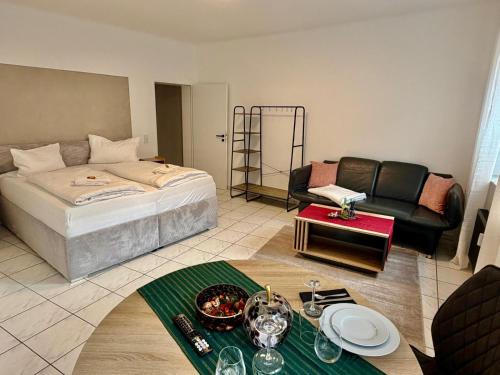 a room with a bed and a couch and a table at Modernes Studio im Herzen von Würselen, gemütlich, zentral & mit Netflix in Würselen