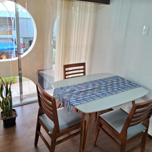 a table and chairs in a room with a window at Apartamento aconchegante na Asa Norte in Brasilia