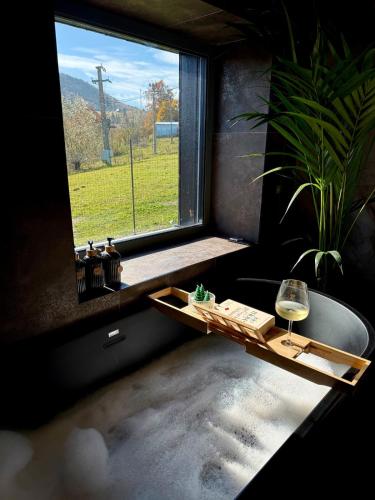a room with a window with a bath tub and a wine glass at Nordic Star Chalet in Fundata