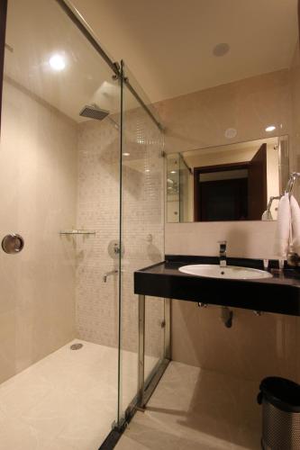 a bathroom with a sink and a glass shower at Hotel Hyderabad Grand in Shamshabad
