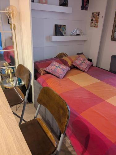 a bedroom with a colorful bed with a table and chairs at Cosy renovated little nest in historic MONTMARTRE in Paris