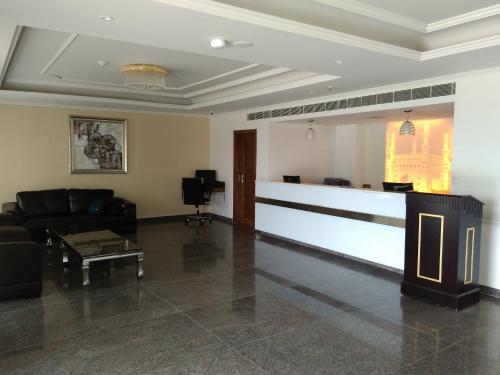 a living room with a couch and a bar at Hotel Hyderabad Grand in Shamshabad