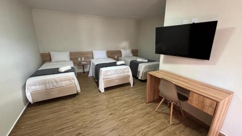 a room with two beds and a flat screen tv at 44 Residence in Belém