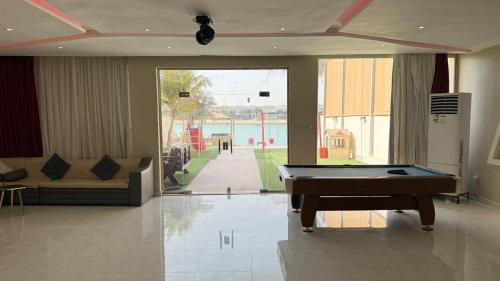 a living room with a pool table and a couch at فيلا السعادة بيتش درة العروس رملي وخاص in Durat  Alarous