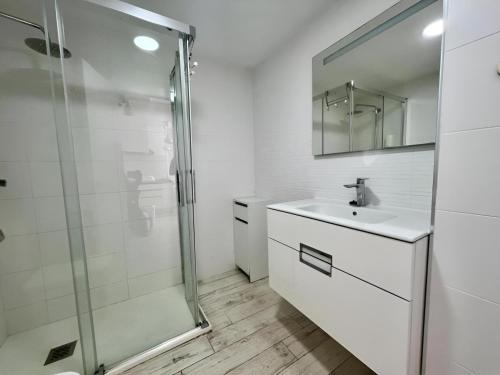 a white bathroom with a sink and a shower at Apartamento Benalbeach in Benalmádena