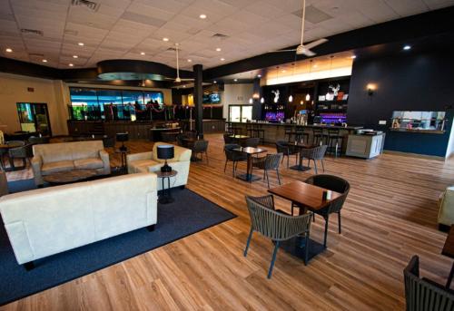 a lobby with tables and chairs and a bar at Paradise Stream Resort in Cresco
