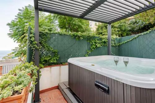 een hottub op een terras met twee wijnglazen bij DIMORA DISIU - Jacuzzi & Sea View - 4 minuti a piedi dal centro in Taormina