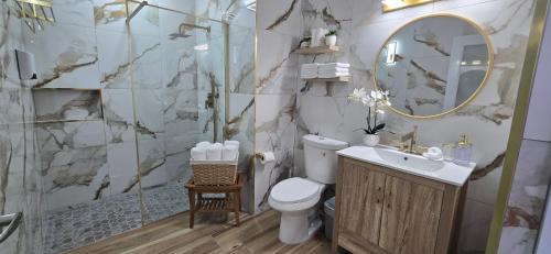 a bathroom with a toilet and a sink and a shower at Boho Chic Relaxing Space in Fajardo