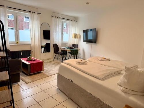 a bedroom with a bed and a living room at Modernes Studio im Herzen von Würselen, gemütlich, zentral & mit Netflix in Würselen