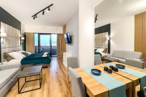 a living room with a table and a couch at ANS Hanza Tower Apartment no 410 - Swimming pool and saunas not opened from 12-28 November in Szczecin
