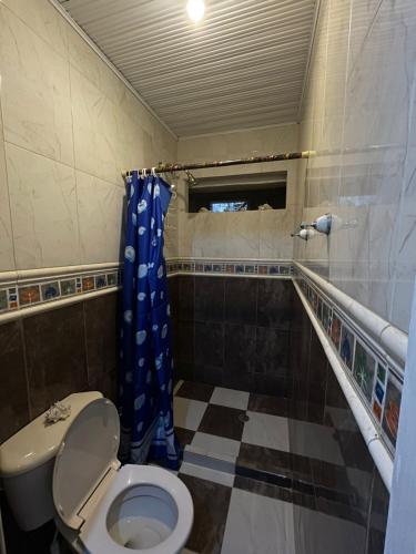 ein Bad mit einem WC und einem blauen Duschvorhang in der Unterkunft Casa turística Cartagena De Indias in Cartagena de Indias