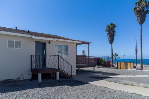a house with a balcony and palm trees and the ocean at New Casa Marea #2 Beach Front House 2BR Wifi AC in Colonia Cuauhtemoc
