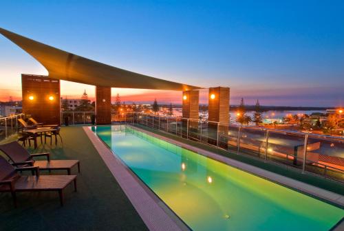 ein Schwimmbad auf dem Dach eines Gebäudes in der Nacht in der Unterkunft Mantra Quayside Port Macquarie in Port Macquarie