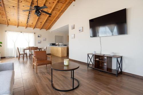 a living room with a couch and a tv and a table at NEW Casa Marea Beach Front House DT 2BR WiFi & AC in Colonia Cuauhtemoc