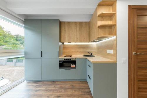 a kitchen with white cabinets and wooden counters at Studija-butas Markučiuose in Vilnius