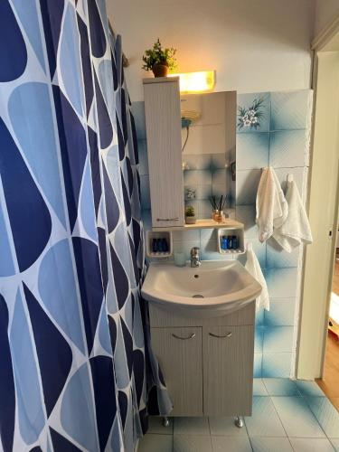 a bathroom with a sink and a blue and white wall at Cozy Corner Marmara Paros in Dhragoulás