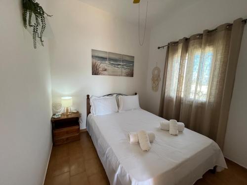 a bedroom with a white bed with towels on it at Cozy Corner Marmara Paros in Dhragoulás