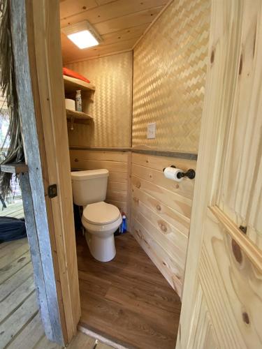 a bathroom with a toilet in a wooden cabin at Magical Treehouse Mountain Views Dog Friendly in Copperhill