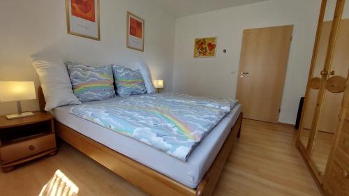 a bedroom with a bed with a rainbow comforter at Deichkrone in Horumersiel