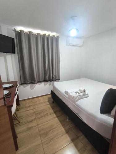 マカエにあるVaccani Apartのベッドと机と窓のある寝室
