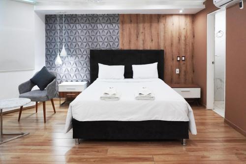 a bedroom with a large bed and a chair at Wyka Hotel in Trujillo