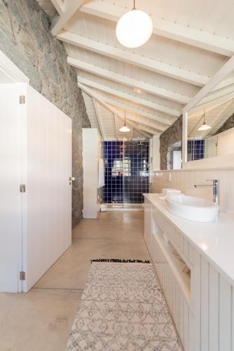 a bathroom with a sink and a mirror at T1 Casa das Pereiras in Calheta de Nesquim