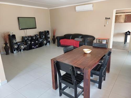 a living room with a wooden table and a couch at Watergat guest house in Rehoboth