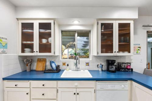 a kitchen with white cabinets and a blue counter top at Shorewood Retreat -10 mins to Seattle-private yard in Burien
