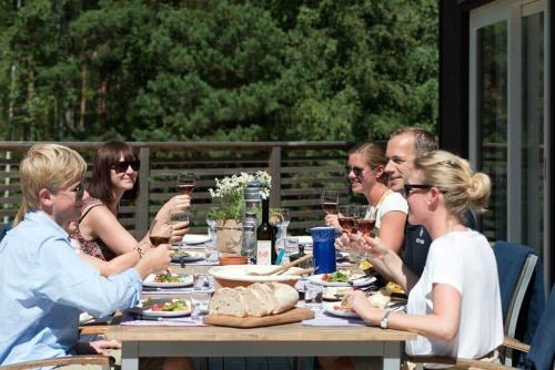 a group of people sitting around a table drinking wine at OGO730-Vikbolandet-Vaerldens-Aende-46 in Arkösund