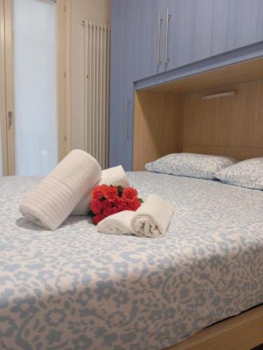 Un dormitorio con una cama con dos almohadas y flores. en Miramare4, en Ceriale