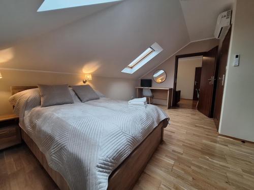 a bedroom with a large bed and a skylight at Aparthotel Xavito in Sanok