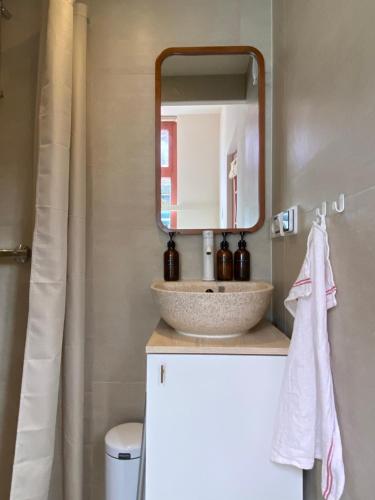 ein Badezimmer mit Waschbecken und Spiegel in der Unterkunft Cosy beach cottage in Zandvoort