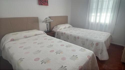 Dos camas individuales en una habitación con una colcha estampada con mariposas. en Casa Clemente en La Bombilla, en Los Llanos de Aridane