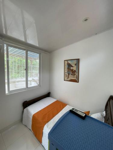 ein kleines Schlafzimmer mit einem Bett und einem Fenster in der Unterkunft Casa turística Cartagena De Indias in Cartagena de Indias