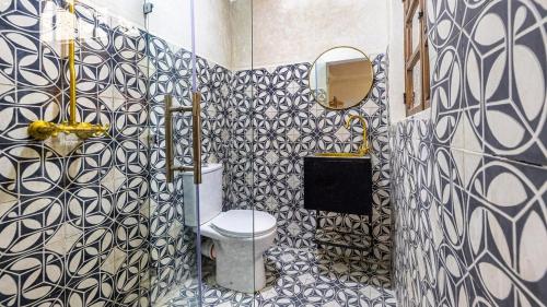baño con aseo y azulejos azules y blancos en Riad Dar Lghizlane, en Marrakech