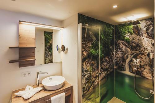 a bathroom with a sink and a shower at Ur-Genuss Lodge mit Wein & Weitblick in Heiterwang