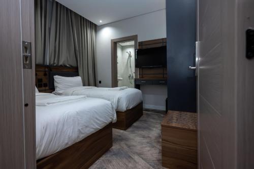 a hotel room with two beds and a mirror at Samama Almaqam Ajyad Hotel Makkah in Mecca