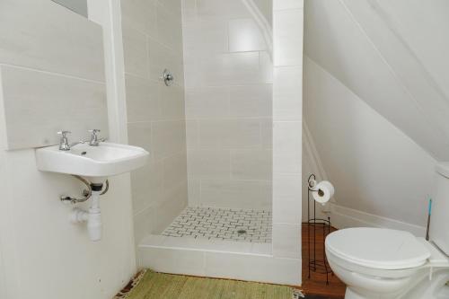 a white bathroom with a toilet and a sink at LUX IN THE AIR - An Elevated Experience on the Vaal Dam in Denysville